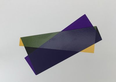 Abstract overlapping colored paper shapes on white background.